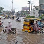Vehicles passing through accumulated rain water after heavy monsoon rain at Committee chowk main Jhang road