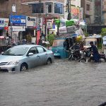 Vehicles passing through accumulated water after heavy rain in the city