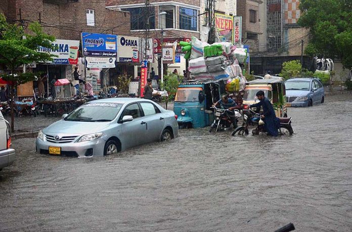 Vehicles passing through accumulated water after heavy rain in the city