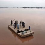 People cross flood water on a boat after river Ravi water entered in their houses at Village Naul Manga Mandi 30 Kilometer from the Provincial Capital