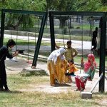 Children enjoying swing at zoo
