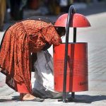 Gypsy woman collecting valuables from dustbin at G9 weekly Bazaar