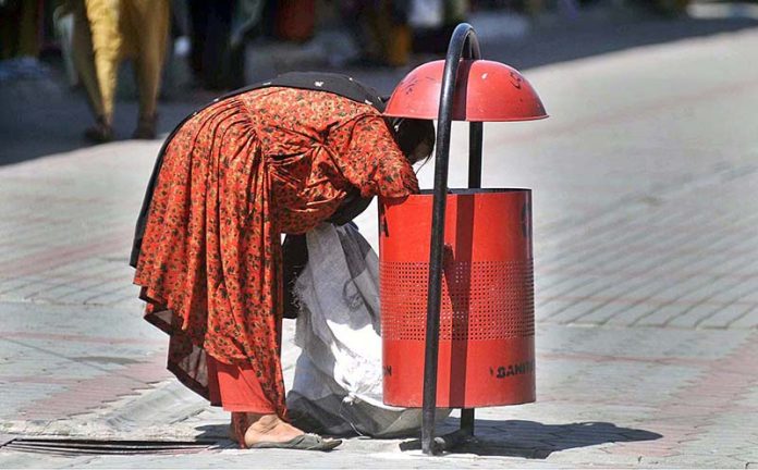 Gypsy woman collecting valuables from dustbin at G9 weekly Bazaar