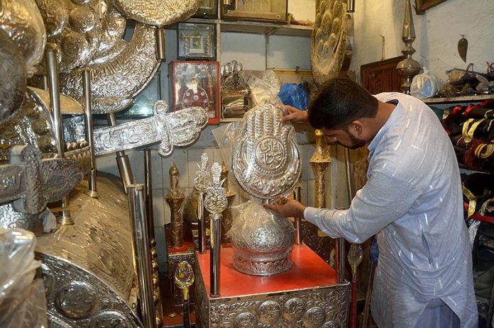 A worker preparing Moharam ul Haram related stuff at his workplace