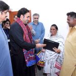 Chairman PPP and Foreign Minister Bilawal Bhutto Zardari giving away house ownership right document to flood victims under the Sindh People's Housing Scheme during a visit to a house built for them at village of Vikia Sangi