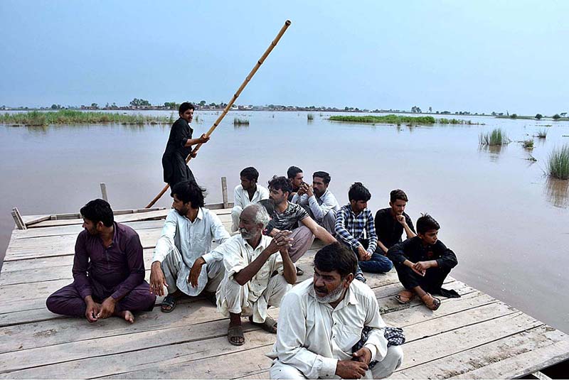 People cross flood water on a boat after river Ravi water entered in their houses at Village Naul Manga Mandi 30 Kilometer from the Provincial Capital