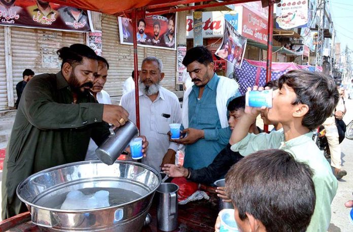 Volunteers serving drinks (Sabeel) to the mourners during the Ashura procession on 9th Muharram-ul-Harram at Nori Gate