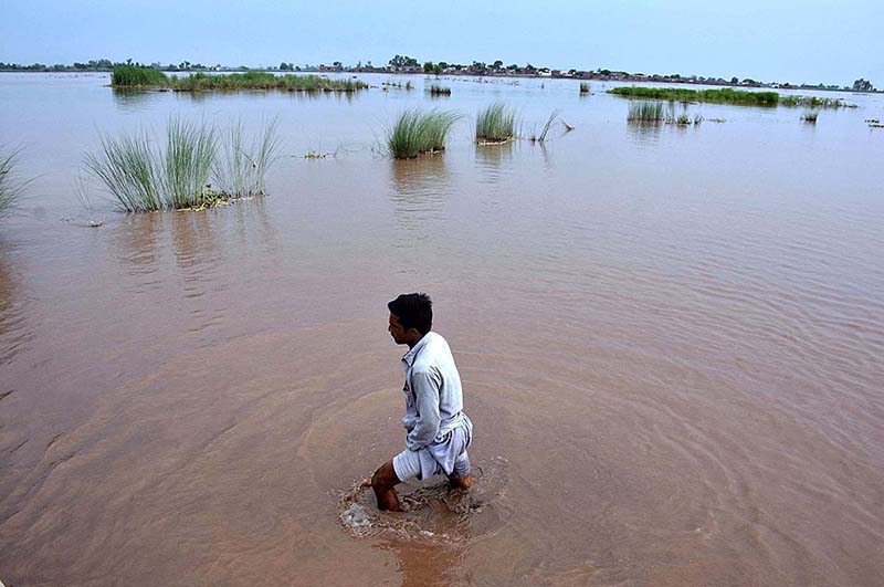 People cross flood water on a boat after river Ravi water entered in their houses at Village Naul Manga Mandi 30 Kilometer from the Provincial Capital