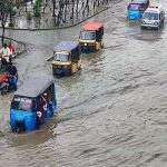 Vehicles passing through rainwater accumulated on road after heavy rain in Provincial Capital