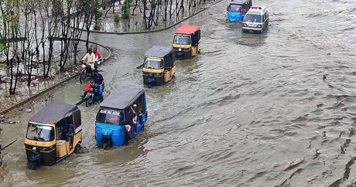 Vehicles passing through rainwater accumulated on road after heavy rain in Provincial Capital