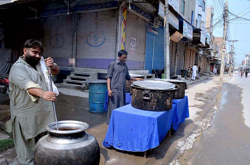 Volunteers serving drinks (Sabeel) to the mourners during the Ashura procession on 9th Muharram-ul-Harram at Nori Gate