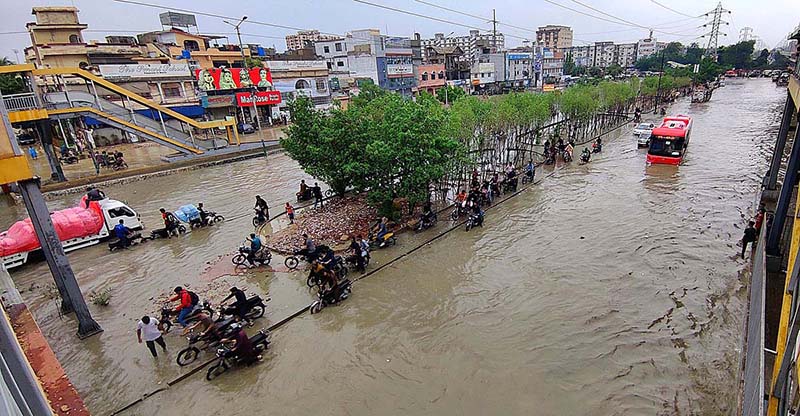 Vehicles passing through rainwater accumulated on road after heavy rain in Provincial Capital