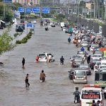 Vehicles passing through rain water accumulated on the road near Kalma Chowk during rain that experienced in the city