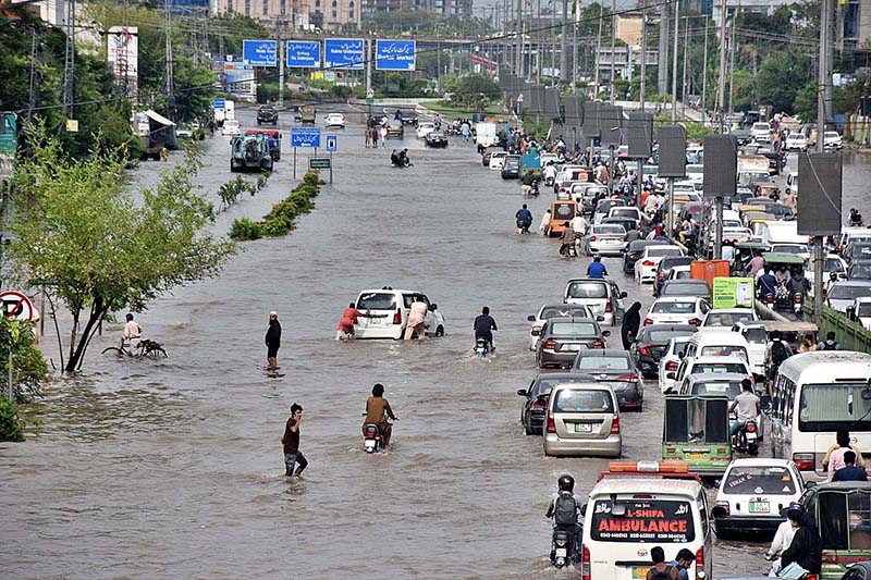 Vehicles passing through rain water accumulated on the road near Kalma Chowk during rain that experienced in the city