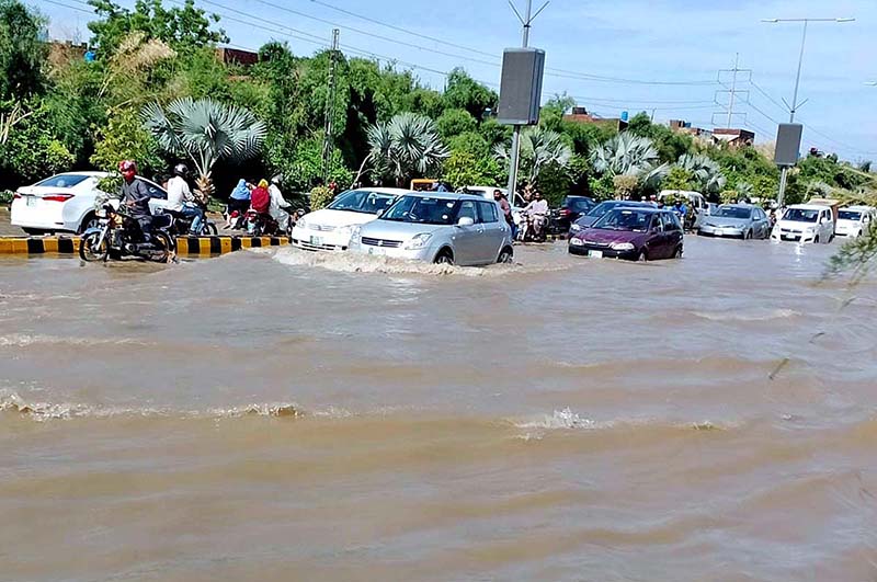 Vehicles passing through rain water accumulated on the road during rain that experienced in the city