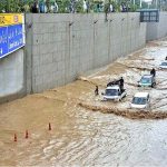 Vehicles passing through rain water accumulated on the Kalma Chowk underpass road during rain that experienced in the city