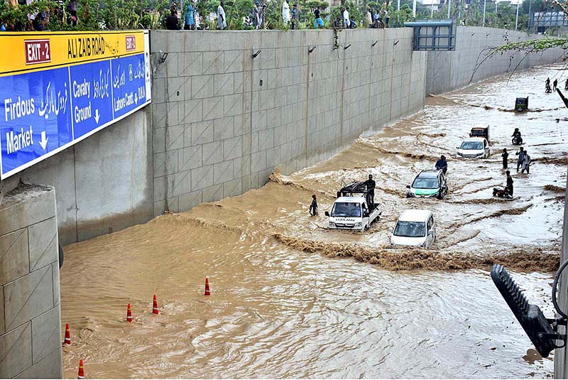 Vehicles passing through rain water accumulated on the Kalma Chowk underpass road during rain that experienced in the city