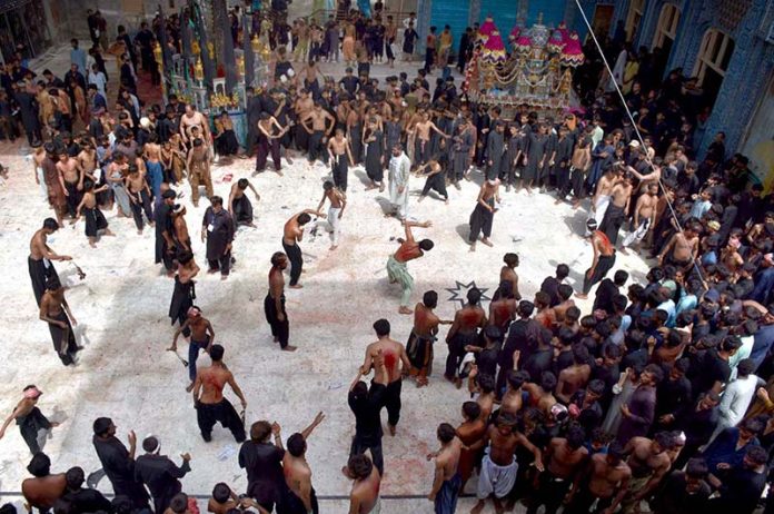 Mourners flagellate themselves with knifes on chains during the procession of Ashura on the 10th Muharram. Ashoura is the commemoration marking the Shahadat (death) of Hussein (AS), the grandson of the Prophet Muhammad (PBUH), with his family members and some of his companions massacred in battle of Karbala for the upright of Islam