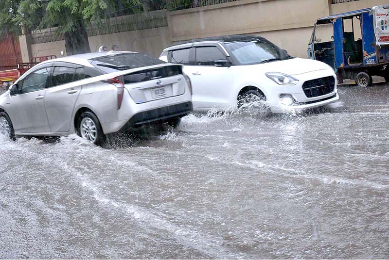 Vehicles are passing through the water during heavy rain in the city