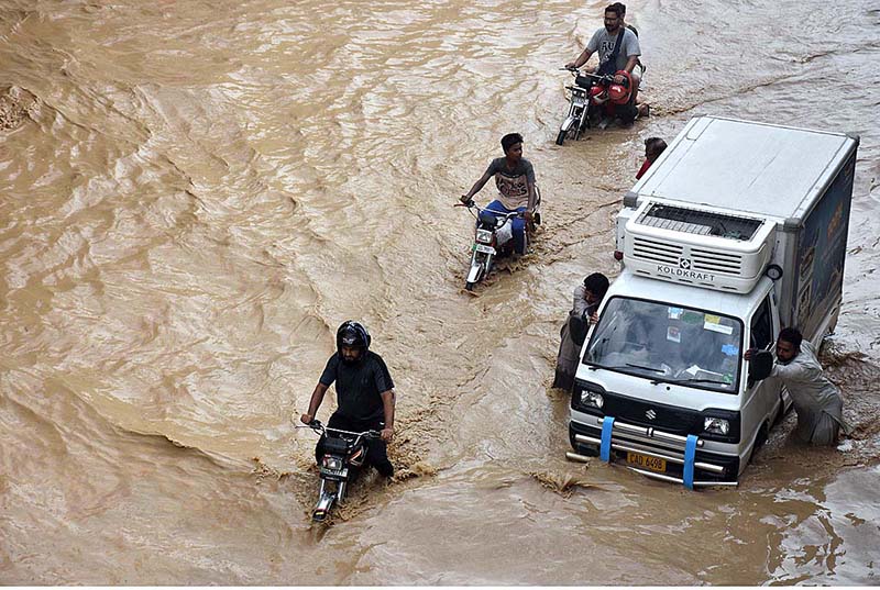 Vehicles passing through rain water accumulated on the Kalma Chowk underpass road during rain that experienced in the city