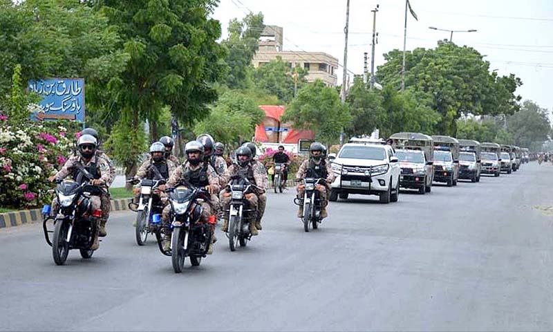 Security personnel conducting flag march regarding maintain law and order during Muharram