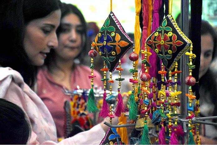 Visitors looking at handmade stuff during Dastkaar Mela organized by Punjab Small Industries in cooperation with Government of the Punjab “Pakistan Handicraft Shops Promoting Artisans and Handicrafts
