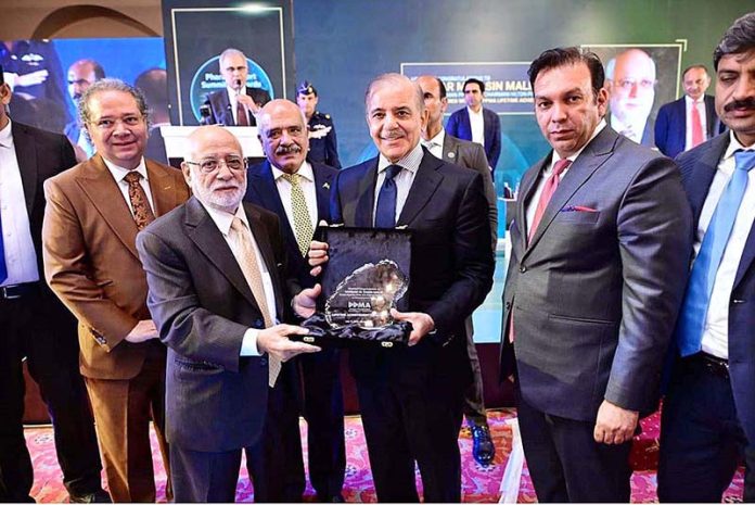 Prime Minister Muhammad Shehbaz Sharif presenting lifetime achievement award to Sardar M. Yasin Malik during Pharma Export Summit & Awards ceremony