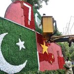 PHA workers decorate the sign board with artificial flowers and preparing the Pakistan and China flags to mark the 76 years of Pak-China Friendship at Mall Road