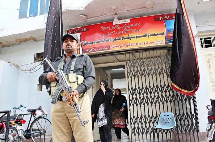 Security personal standing high alert in front of Imambargah