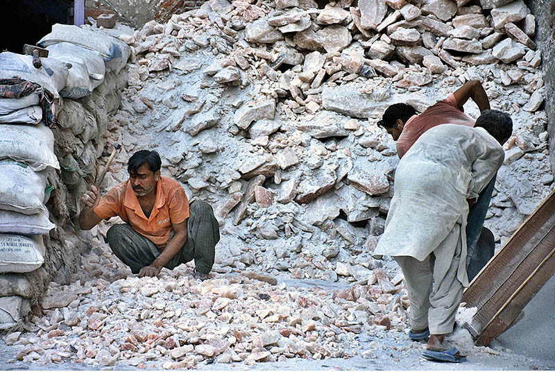 Labourers busy in crashing rocks of Pink salt into small pieces at their work place in Provincial Capital City