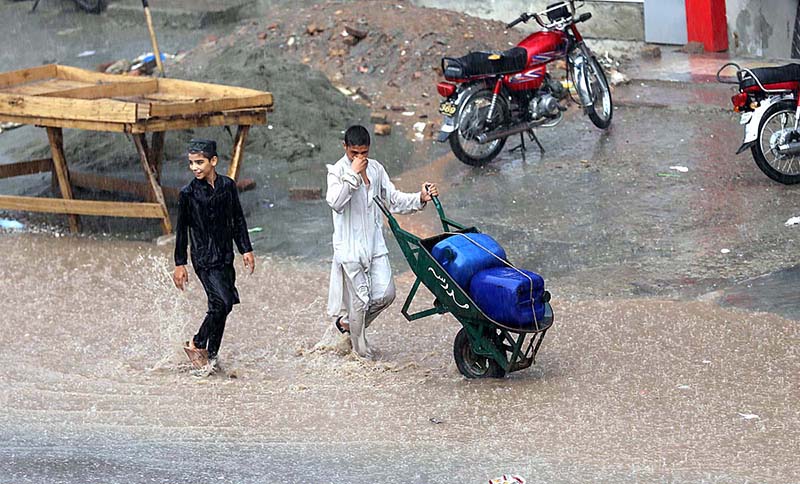Children enjoying play in rain water on the road at Ghouri Town