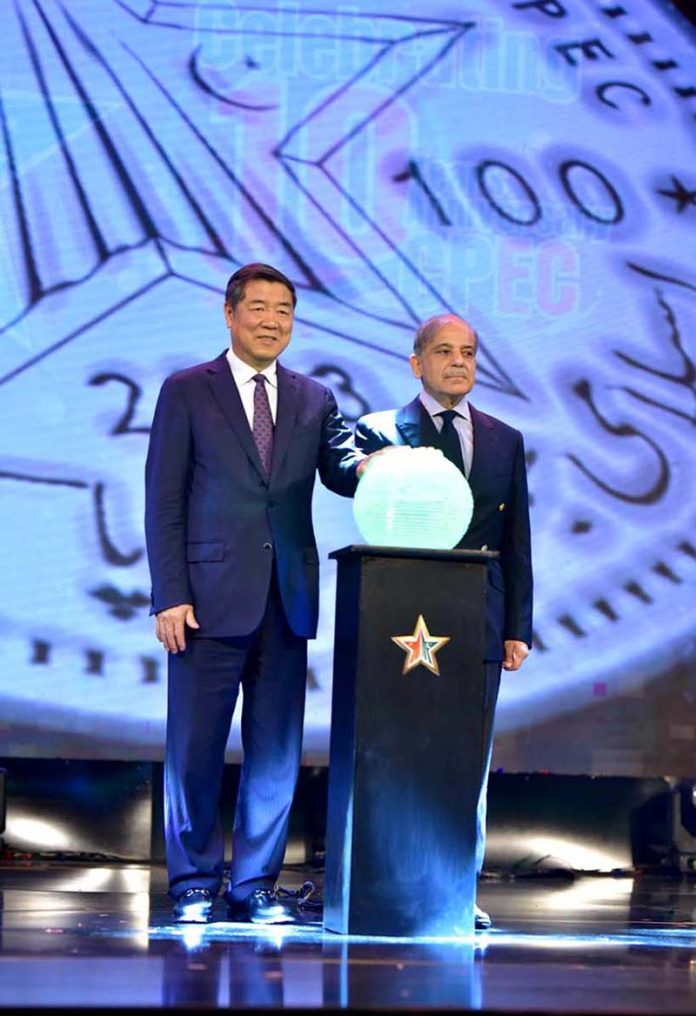 Prime Minister Muhammad Shehbaz Sharif and Vice Premier of China Mr. He Lifeng pushing a digital button to launch a commemorative coin of Rs.100 at a ceremony to celebrate the 10th anniversary CPEC