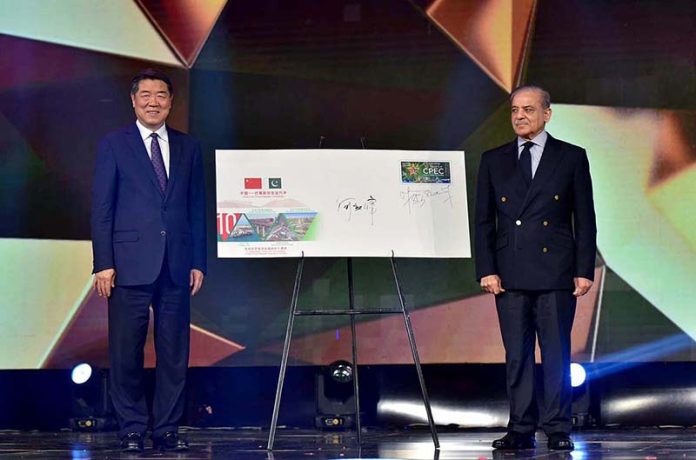 Prime Minister Muhammad Shehbaz Sharif and Chinese President Special Representative and Vice Premier of China Mr. He Lifeng signing the First Day Cover of a commemorative postal stamp at ceremony to celebrate the 10th anniversary of CPEC