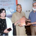 The book writer Akram Sahar Farani gives away his book to a person during the literary session Mushaira and the launch of his book at Al Hamra Arts Council