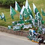 Vendor displaying National flags to attract the customers as the nation starts preparations to celebrate Independence Day in befitting manners at roadside