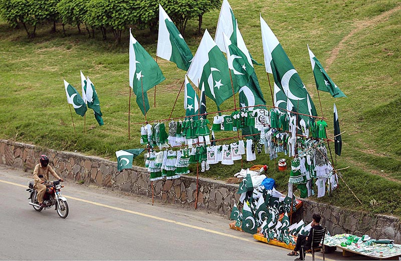 Vendor displaying National flags to attract the customers as the nation starts preparations to celebrate Independence Day in befitting manners at roadside