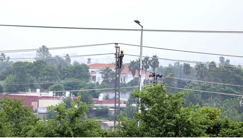 A WAPDA worker fixing the faulty cables on an electric pylon at Faizabad neighbourhood