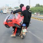 Woman holding a toy car while sitting rear seat of a Motorcycle