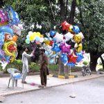A street vendor displaying different kinds of colorful balloons to attract customers at roadside