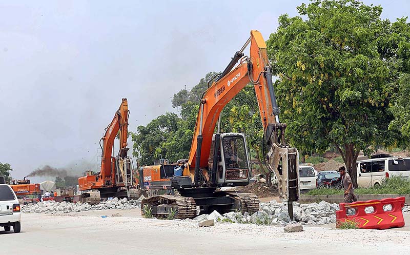 Heavy machinery being used for repairing the Islamabad Expressway during repairing work in Federal Capital