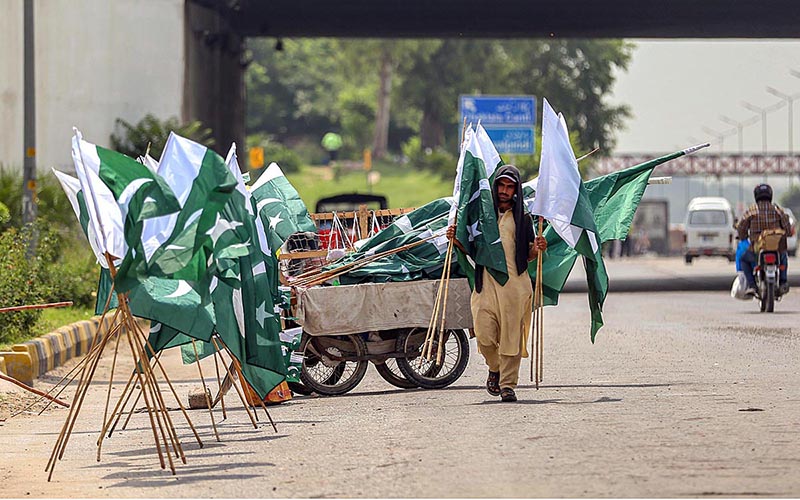 Vendor displaying National flags to attract the customers as the nation starts preparations to celebrate Independence Day in befitting manners at roadside