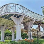 Labourers busy in painting overhead bridge at Islamabad Expressway in Federal Capital