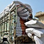 Labourers busy in unloading heavy sacks from transportation truck at Shahi Bazaar
