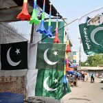 A vendor displaying national flags to attract the customers at his roadside setup in connection with upcoming Independence Day celebrations