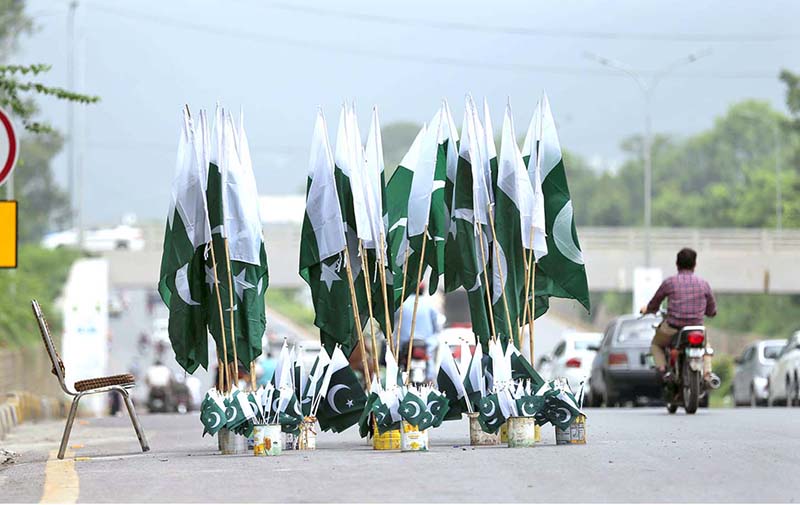 A vendor displaying national flags and other stuffs related to Independence Day celebrations on Murree Road