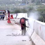 A worker busy in finishing work of road dividers during construction work on Islamabad Expressway