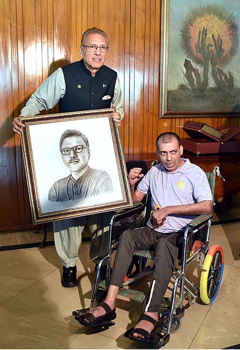 President Dr Arif Alvi receiving his portrait made by Mr Umer Jarral, an artist with cerebral palsy, at Aiwan-e-Sadr