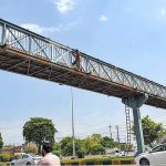 Workers busy in paint the overhead pedestrian bridge at Islamabad Expressway