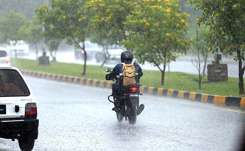 A motorcyclist on the way during rain that experienced the Federal Capital