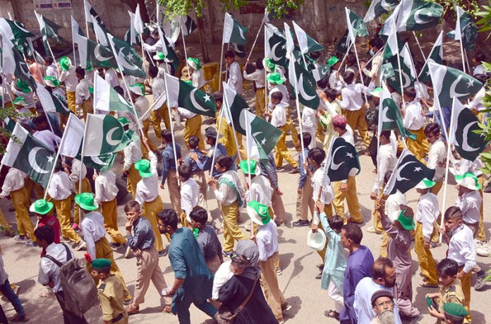 Students of Government high school participating with national flags in a Geo Pakistan rally in connection with Pakistan Independence day celebrations outside Press Club road
